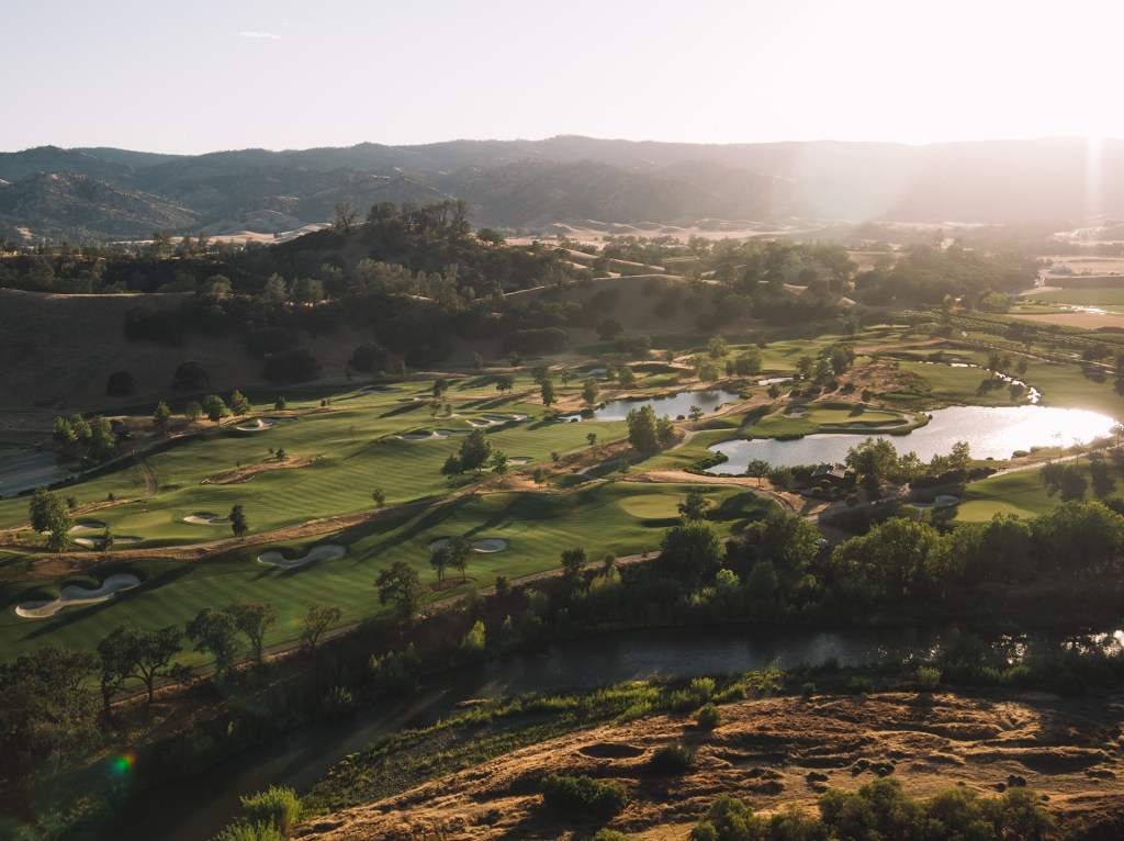Birds eye view of golf course at sunrise