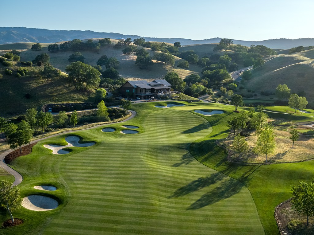 View of golf course with sand traps and hills 